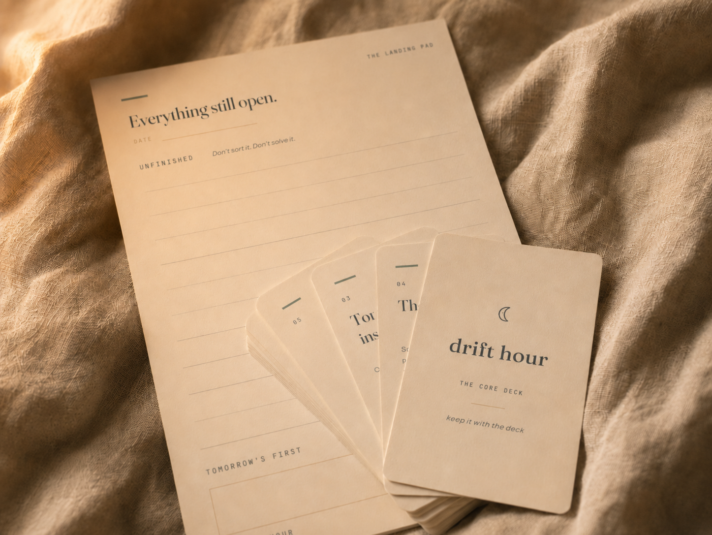 Drift Hour cards fanned out on the Landing Pad sheet under warm lamp light