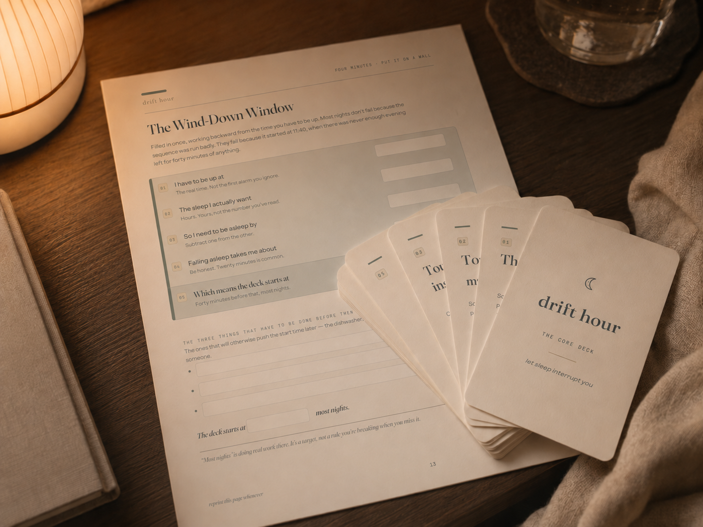 The Nightstand Kit: a filled Landing Pad page, the fanned card deck and a lamp on dark wood